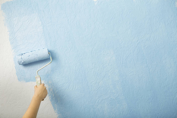 Female hand paints wall with paint roller - Φωτογραφία, εικόνα