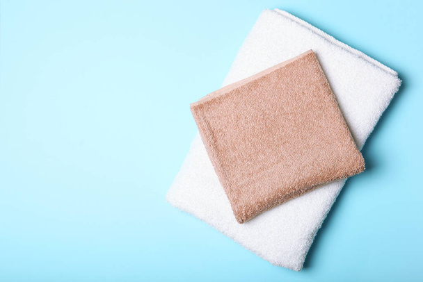 Fresh towels on a colored background with place for text top view. - Photo, Image