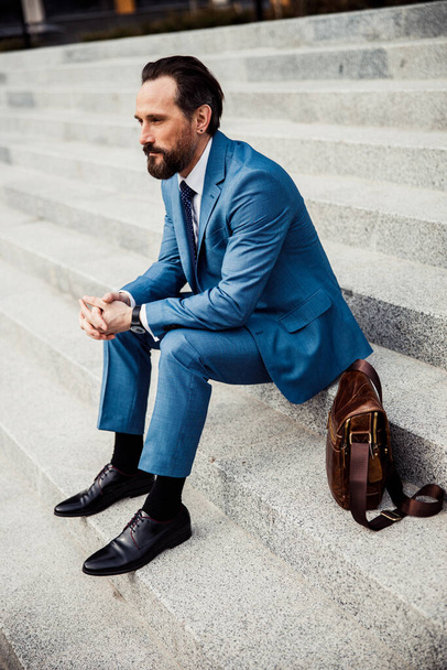 Serious middle-aged Caucasian male entrepreneur sitting outside - Fotografie, Obrázek