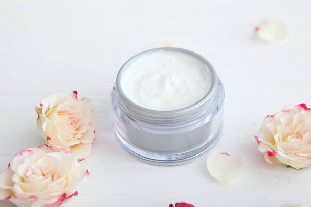 skincare cream and flowers on the table. Cosmetics for skin care. - Photo, Image