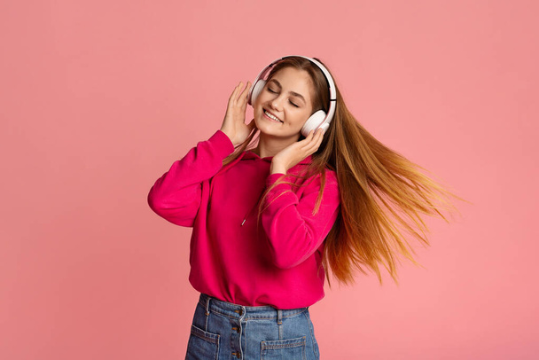 Happy teenage girl dancing in headphones, free space - Foto, afbeelding