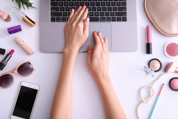 Beauty blog concept. Modern laptop and female hands, cosmetics top view on a nesting background. Freelance, blog, internet, post. - Photo, Image