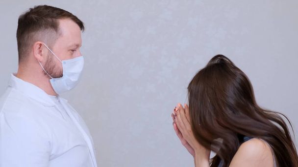 Hasta kadın grip ya da soğuk algınlığı belirtileri gösteriyor ve bir doktorun yanında hapşırıyor..  - Fotoğraf, Görsel