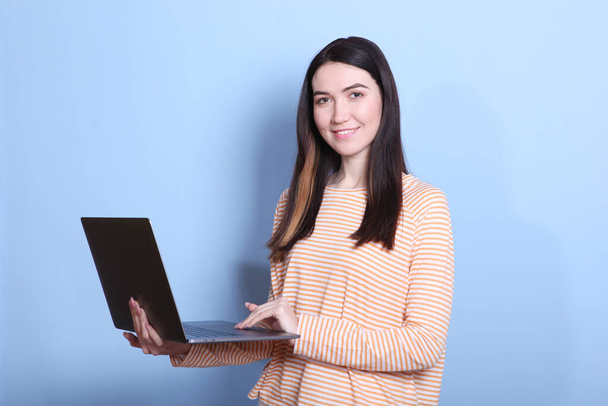 dívka drží moderní notebook na barevném pozadí. - Fotografie, Obrázek