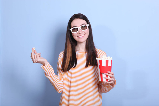 girl with popcorn on a colored background. Watch a movie, 3D movie. - Fotoğraf, Görsel