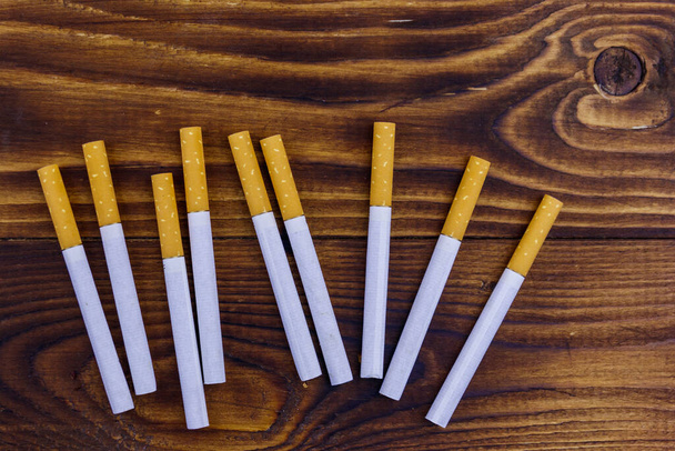 Тютюнові сигарети на дерев'яному столі
 - Фото, зображення