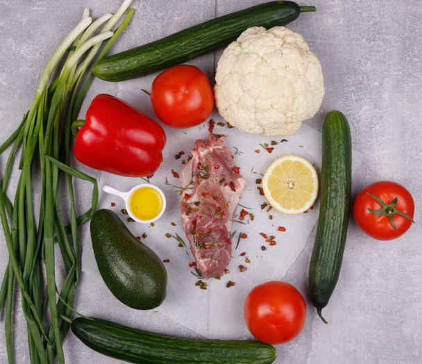 Fresh meat and vegetables for cooking your favorite dishes on a light background. View from above. - Фото, зображення