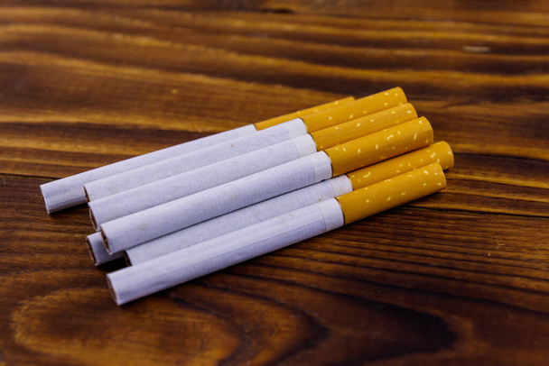 Тютюнові сигарети на дерев'яному столі
 - Фото, зображення