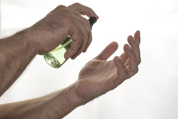 Ο άνθρωπος χρησιμοποιεί αλκοολούχο απολυμαντικό χεριών. Πρόληψη από τον κορωνοϊό σε άλλες μολυσματικές ασθένειες. Έννοια υγιεινής - Φωτογραφία, εικόνα