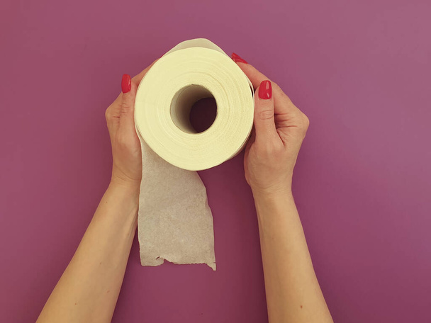 женские руки с туалетной бумагой на цветном фоне
 - Фото, изображение
