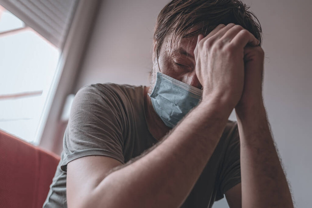 Переживающий стресс человек изолирован в домашнем карантине во время пандемии коронавируса ковида-19, избирательный фокус
 - Фото, изображение