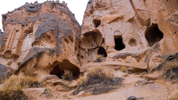 Fairy chimneys and cave houses surrounded by rock formations at Zelve Valley in Cappadocia, Turkey - Foto, imagen