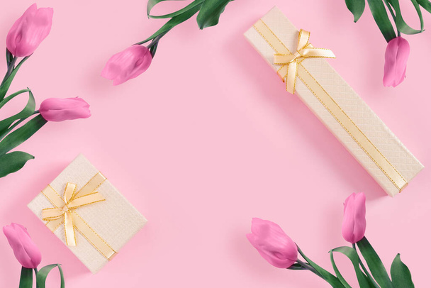 Beautiful pink tulips with gold gift box on  pink paper background. Top view, flat lay, copy space concep - Zdjęcie, obraz