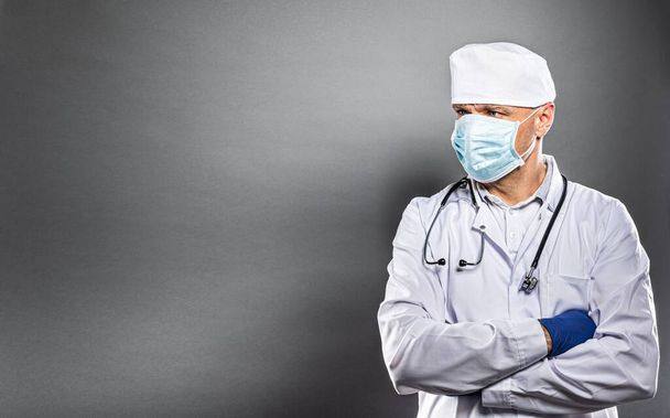Mężczyzna lekarz w białym mundurze i ochronnej maski medycznej - Zdjęcie, obraz