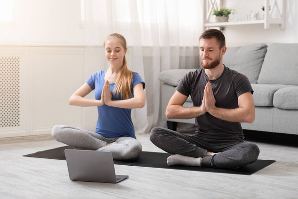 Молода пара тисячоліть практикує йогу з інструктором онлайн
 - Фото, зображення