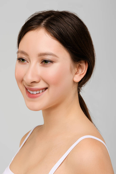 Portrait of beautiful happy asian girl in white t-shirt and natural makeup - Fotó, kép