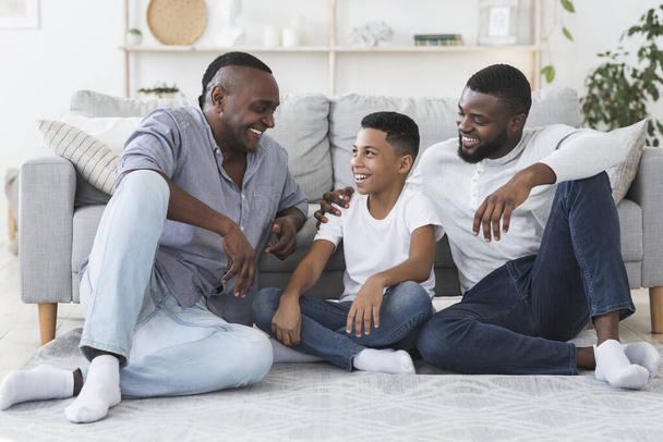 Famiglia maschile. Nonno, Padre e Figlio che riposano sul pavimento di casa
 - Foto, immagini