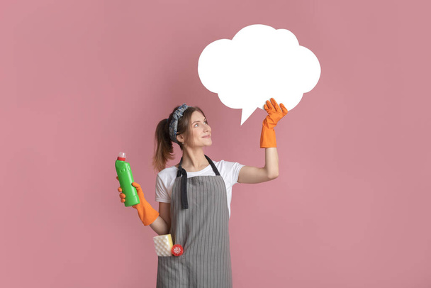 Веселая домохозяйка в фартуках и домашних перчатках, держащая пустой пузырь речи
 - Фото, изображение
