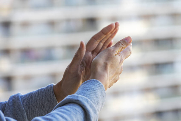 Ženské ruce tleskají zdravotnickému personálu z balkónu. Lidé ve Španělsku tleskají na balkónech a oknech na podporu zdravotnických pracovníků, lékařů a sester během pandemie koronaviru - Fotografie, Obrázek