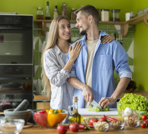 Homme et femme dans leur cuisine à la maison préparant le dîner
 - Photo, image