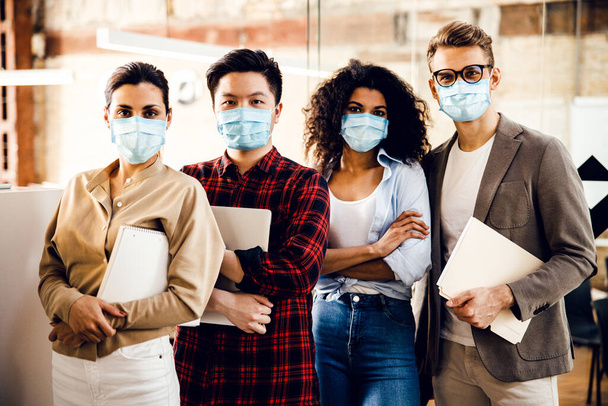 Multiracial young people in medical masks standing in office - Photo, Image