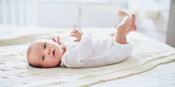 Adorable baby girl lying on bed in nursery - Φωτογραφία, εικόνα