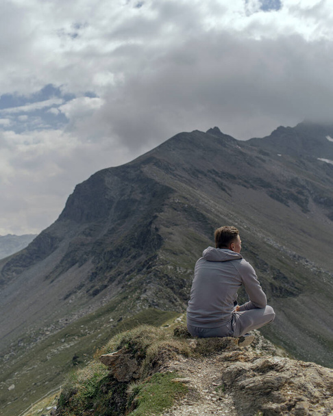 Jeune homme médite au sommet de la montagne alpine
 - Photo, image