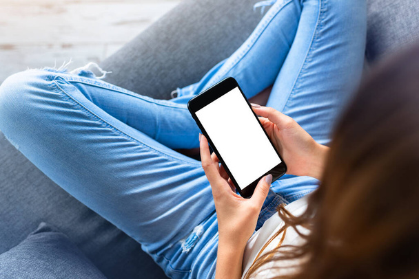 Woman takes a rest with smartphone, on sofa - Photo, image