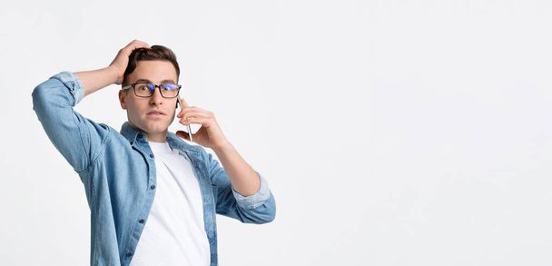 Překvapený muž mluví po telefonu a drží se od hlavy k hlavě - Fotografie, Obrázek