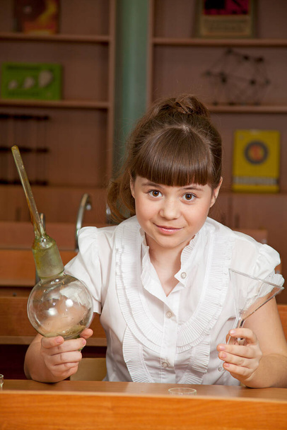 the schoolgirl doing chemistry experiment on the lesson - Foto, immagini
