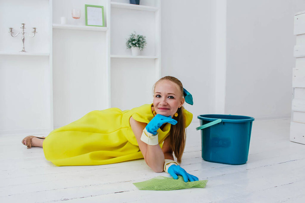 Blonde girl with a mop and a rag on the floor - Φωτογραφία, εικόνα