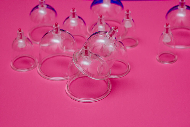 Jars for hijama. Vacuum pumps on a pink background - Foto, afbeelding