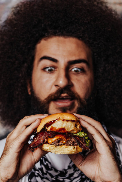 Curly freelancer want to eat craft mouth-watering bacon and angus beef burger. Best concept to promote burger place. - Fotografie, Obrázek
