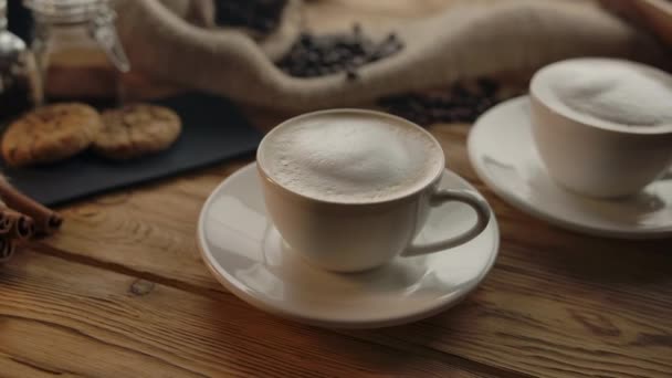 A womans hand takes one of two cups of coffee off the table - Footage, Video