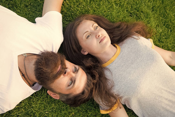 couple lie on green grass. man and woman relax outdoor. dreaming concept. Dating concept. bearded hipster and girl carefree. Youth and freedom. Closer to nature. couple feel free. Freshness and peace - Φωτογραφία, εικόνα