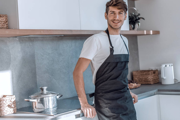 attractive young man standing near the kitchen table - Photo, Image