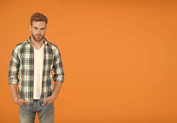 Make You Look Good. copy space. casual fashion for men. Masculine Outfits And Look. stylish male in fashionable clothing. handsome man in checkered shirt and jeans. student orange background - Foto, afbeelding