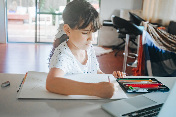 sisäkuva nuori valkoihoinen tyttö piirustus kotona, kotiopetus, verkko-oppiminen
 - Valokuva, kuva