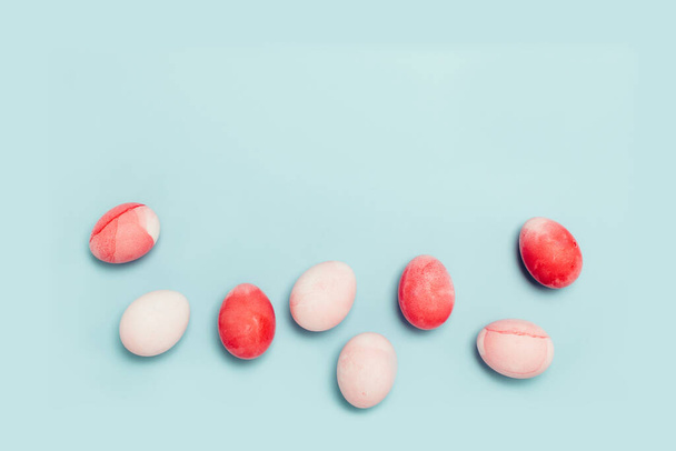 Leuke lichtblauwe achtergrond met roze eieren - Foto, afbeelding