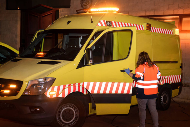 Scène nocturne d'un ambulancier paramédical méconnaissable, conductrice d'ambulance au travail, prête à intervenir en cas d'urgence
. - Photo, image