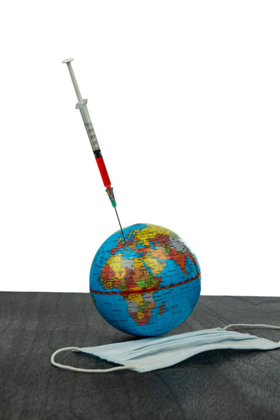 Mask, syringe and earth. An injection against the virus. The  epidemic of coronavirus. Earth Vaccination. Covid 19 in Europe and Usa map. Copy space for text. Isolated on white.  - Photo, image