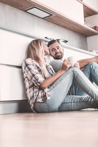 young couple drinking coffee sitting on the kitchen floor - Foto, Imagem