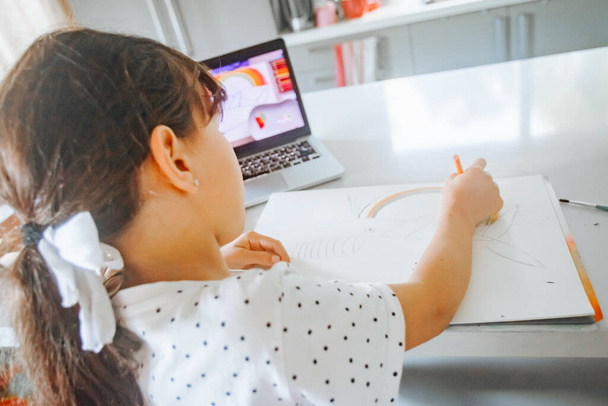 Evde çizim yapan beyaz bir kızın kapalı alanda portresi, evde eğitim, internette öğrenim. - Fotoğraf, Görsel