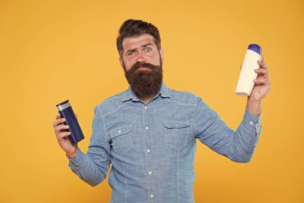 Which shampoo is better for beard. Bearded man choose shampoo for beard hair. Beard products. Care of beard and moustache. Maintaining facial hair. Grooming habits - Foto, imagen