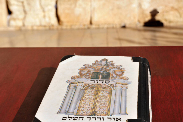 Siddur livro contra o Ocidental Wailing Kotel Wall em Jerusalém cidade velha, Israel. Siddur é um livro de oração judaica, contendo uma ordem definida de orações diárias
. - Foto, Imagem