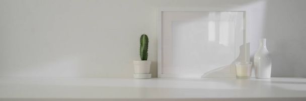 Minimal εσωτερικό σχεδιασμό του σαλονιού με πλαίσιο μακέτα, διακοσμήσεις και αντίγραφο χώρου σε λευκό τραπέζι - Φωτογραφία, εικόνα