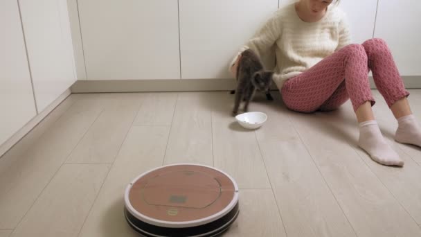Robot porszívó gyűjti a szemetet a konyhában. Modern technológia - Felvétel, videó