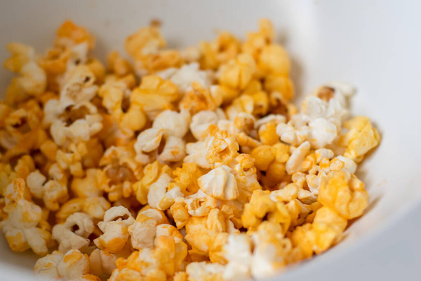 Close up of fresh made popcorn in a white bowl. Entertainment at home concept - Фото, зображення