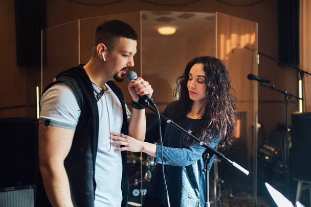 Woman coaching a male vocalist or singer - Photo, image