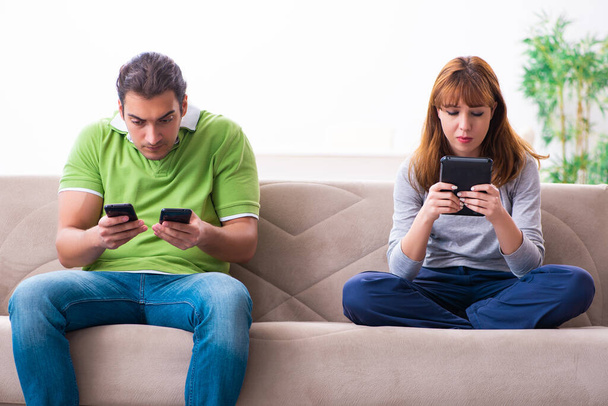 Young couple in gadget dependency concept - Photo, Image